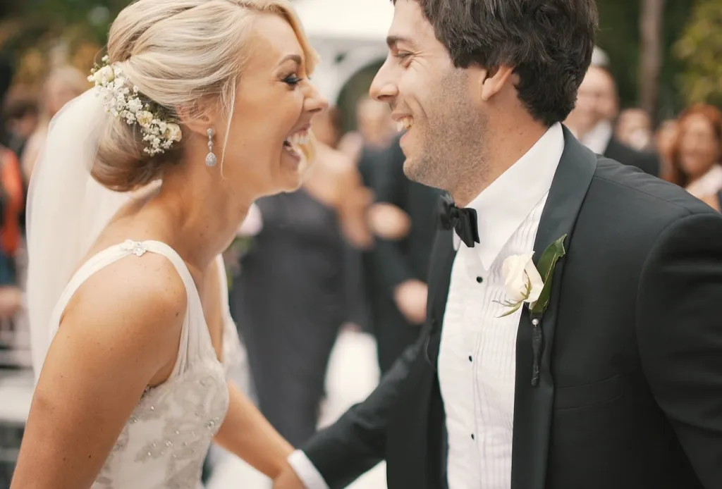 Bride and groom laughing joyfully at the altar during their wedding ceremony.
