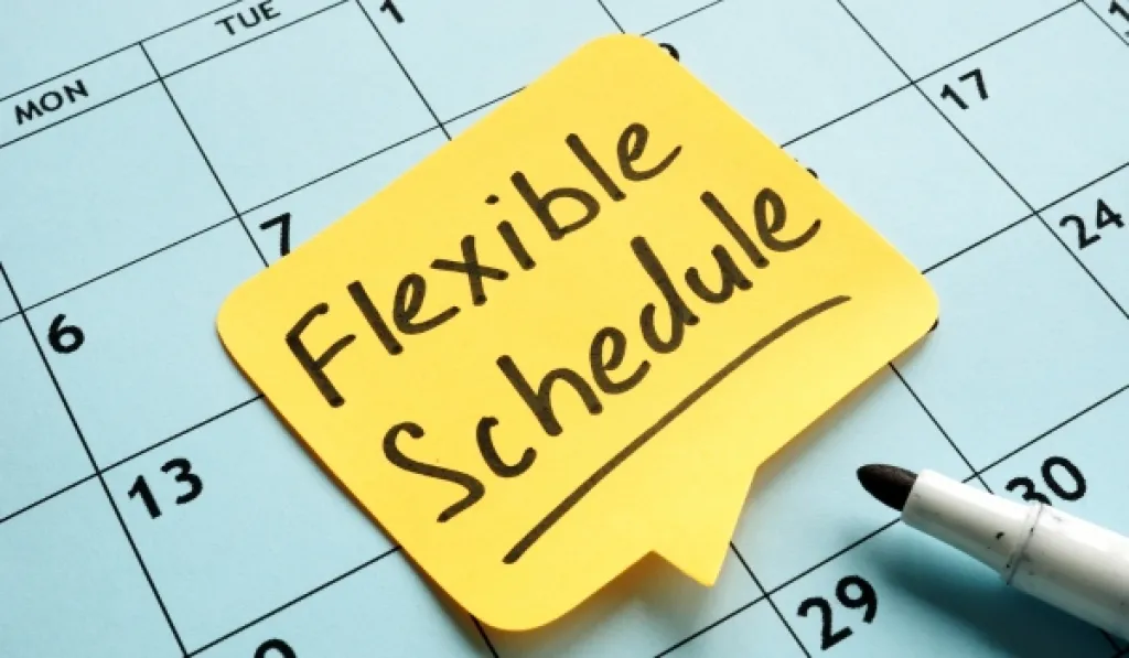 Sticky note reading Flexible Schedule on a calendar page with a marker nearby.