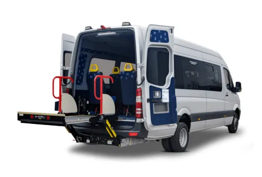 Accessible minibus with rear wheelchair lift and red safety rails for disabled transport.