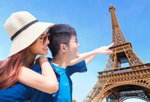 Happy couple sightseeing near Eiffel Tower in Paris on a sunny day.